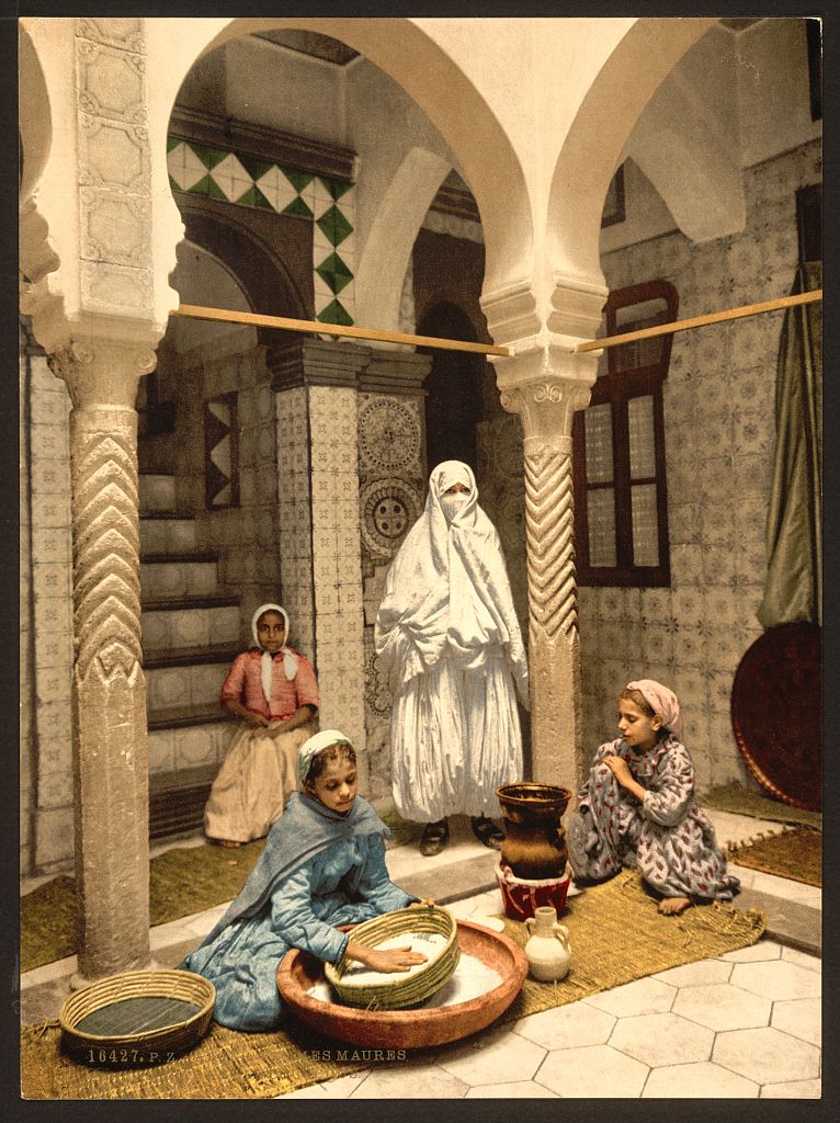 Moorish women preparing couscous by hand in a tiled courtyard, Algiers, c. 1899